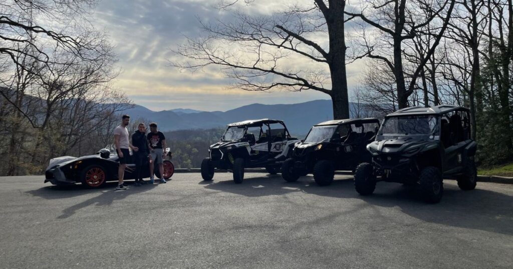Family posing with three UTVs and a Slingshot from RideOn UTV Rentals in the Smoky Mountains near Gatlinburg, TN.